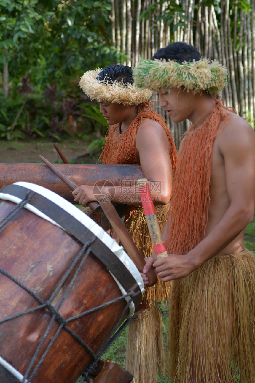 两名库克群岛男子在库克群岛拉罗通加的大型木鼓上演奏音乐真正的图片