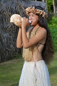 波利尼西亚库克岛民妇女在库克群岛拉罗汤加吹海螺壳背景图片