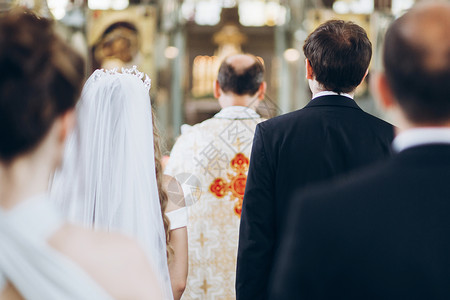新郎和新娘在圣婚期间站在教堂里图片