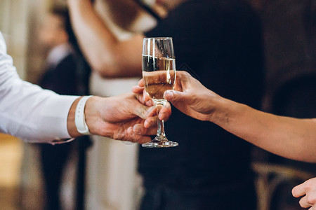 优雅的人在豪华婚宴上拿着香槟杯手在社交活动中喝酒和敬酒服务员提供酒水图片