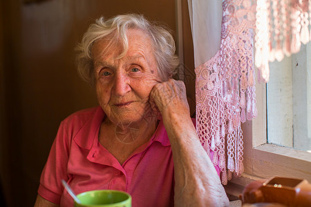老妇人坐在餐桌旁图片