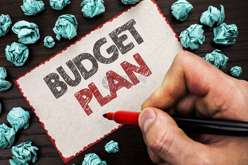 显示预算计划的文本符号概念照片会计策略预算财务收入经济学由持有标记纸板的人在木图片