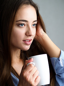 年轻漂亮的微笑女人抱着白杯茶肖像冷天新工作日的美味香气暖饮开背景