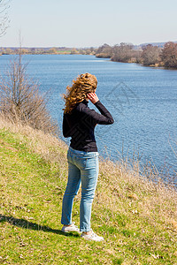 年轻女孩站在河边图片