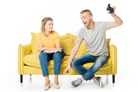 在黄色沙发上的一对夫妇一起玩电子游戏图片