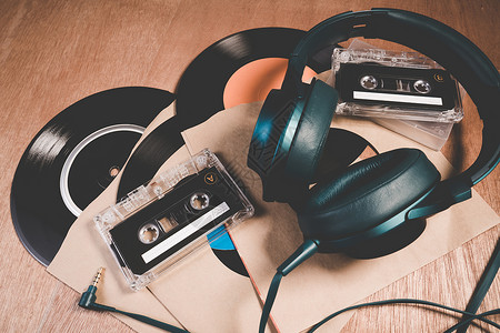 复古录音带和旧老式黑胶唱片在木桌上的集合录音带耳机和留声机唱片或旧黑胶背景图片