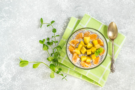 绮里嘉加椰奶蜂蜜芒果和橘子的奇亚布丁配料和准备好的嘉布丁在碗里清洁饮食健康饮食健身理念抗氧化背景