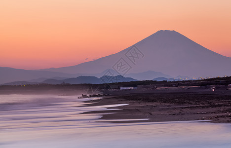 日落背景下的富士山和海浪图片