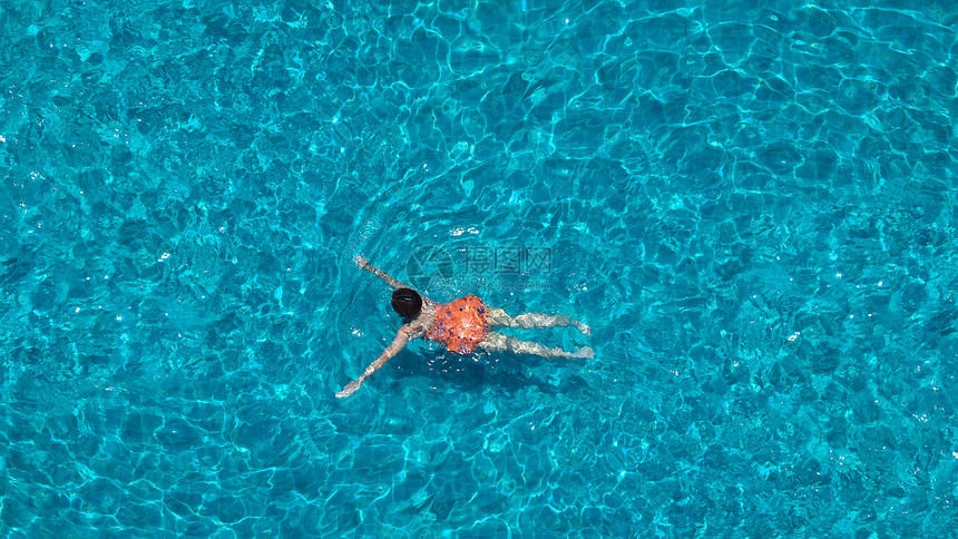 游泳池蓝色清澈的水和人们享受在夏季阳光明媚的白图片