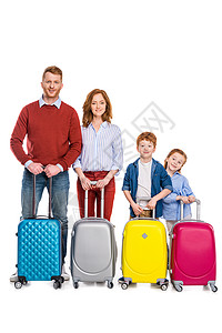 快乐的红发家庭带着五颜六色的手提箱站着图片