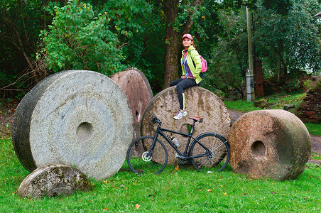 圆形磨石他的磨坊的旧石磨骑自行车图片