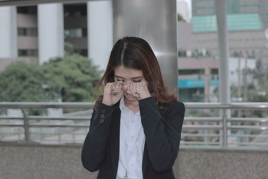亚洲年轻女商人在办公室外用手亲热地哭泣图片