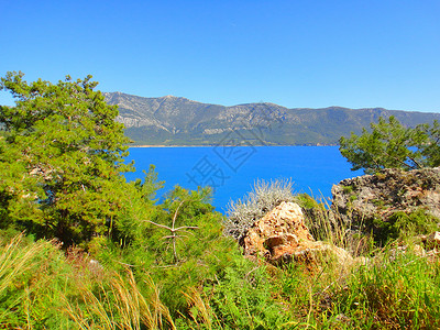 美丽的蓝色海水在温暖阳光明媚的夏日土耳其的石山无边际的大海背景图片