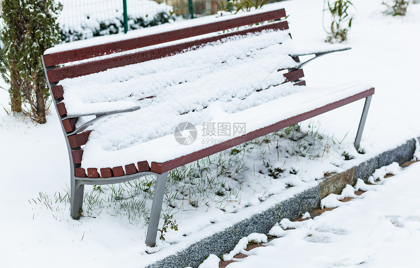 三月天公园里的长凳被雪覆盖图片