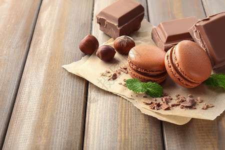 木制背景上的美味马卡龙巧克力和榛子图片