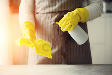 黄色橡胶防护手套上的女人擦扫灰尘和肮脏图片
