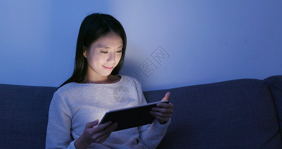 晚上在平板电脑上看书的女人图片