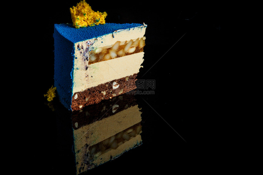 上面有黄海绵蛋糕装饰的蓝色慕斯蛋糕和面上加焦糖梨饼图片