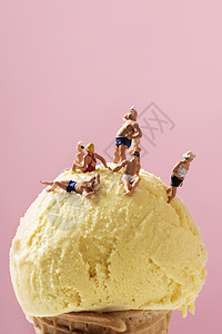 一些穿着泳衣的微型人物在冰淇淋球上放松图片