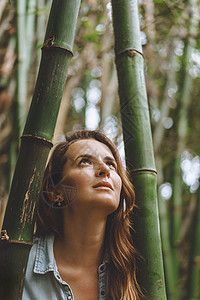 站在竹草植物中间的美丽的穿孔妇女肖像图片