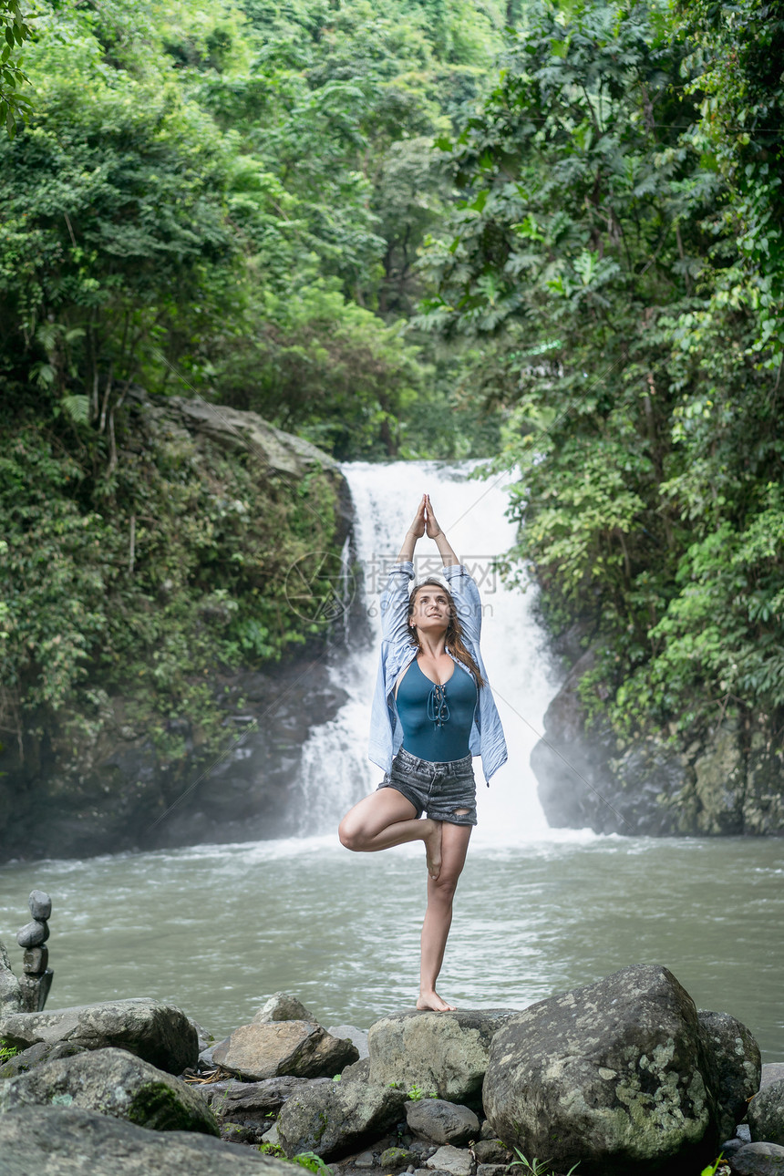 在印度尼西亚巴厘的AlingAling瀑布上做瑜伽的有图片