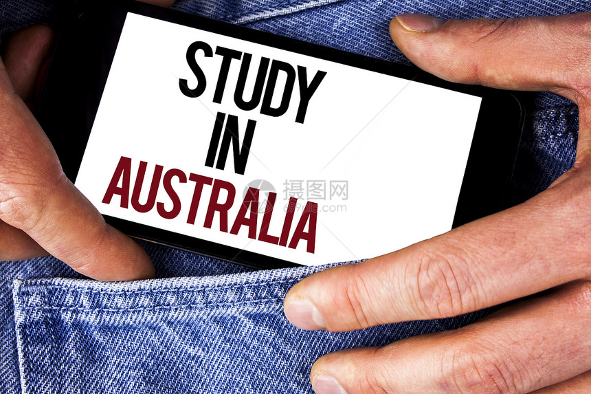 文字写作文本在澳大利亚学习海外大学毕业生的商业理念是由牛仔裤背景男子手持机撰图片
