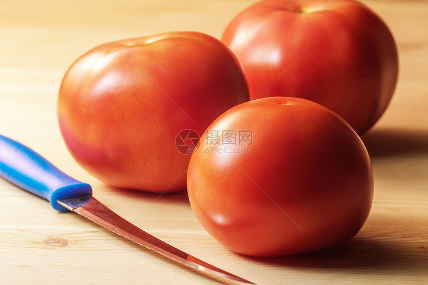 刀子旁边是桌上的三西红柿成熟图片