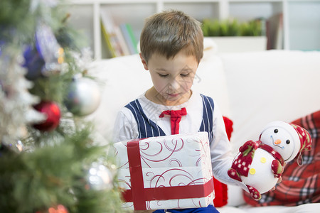 一个带着圣诞礼物的男孩拿一份圣诞礼物孩图片