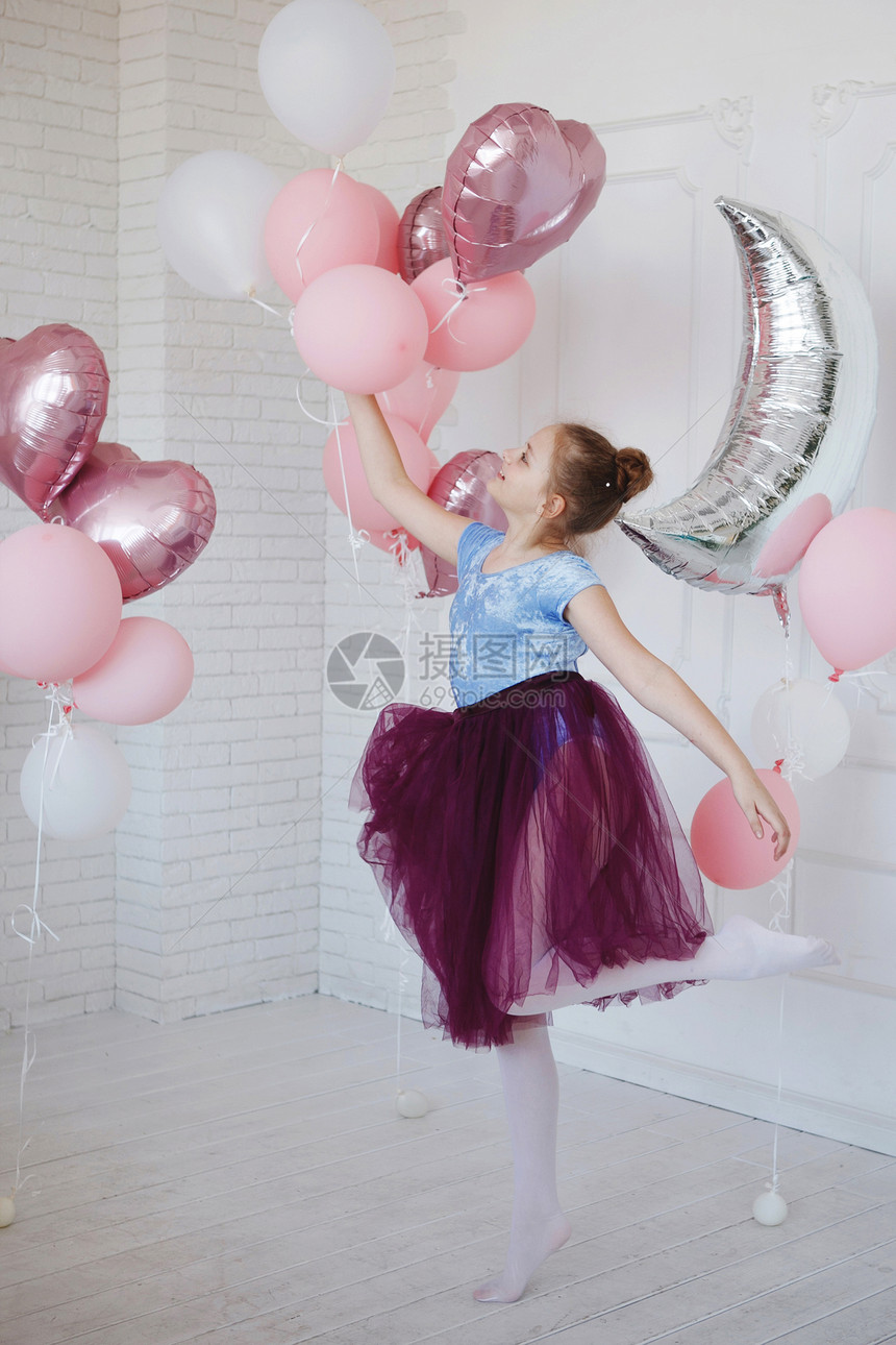 一个穿蓝衣服的年轻芭蕾舞女和一条穿粉色气球的紫裙子图片