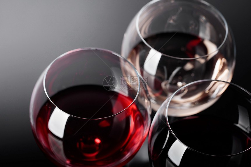 粉红白葡萄酒的玻璃杯在黑暗背景上图片
