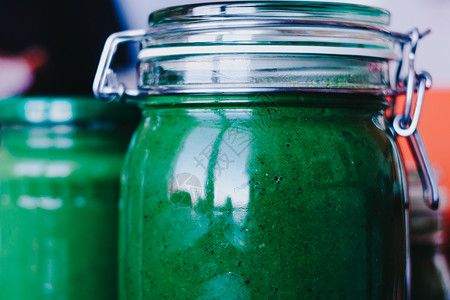 封闭玻璃罐中绿色水果和草药的新鲜绿色果子和蔬菜背景图片