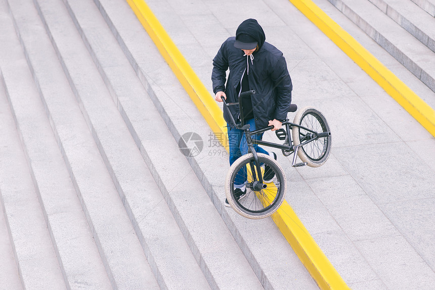 一个时髦的BMX自行车青少年从楼梯下来骑着自行车走图片