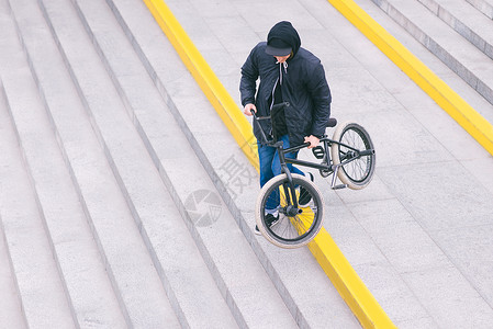 一个时髦的BMX自行车青少年从楼梯下来骑着自行车走图片