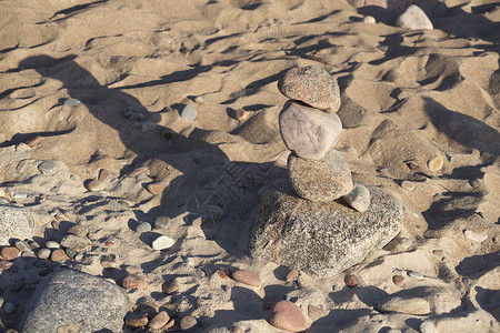 由沙子上的不同巨石制成的石堆图片