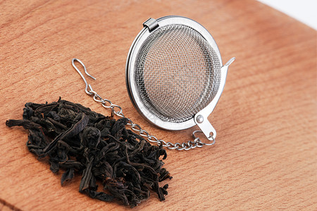 红茶和带链的滤茶器木制背景红茶和滤茶图片