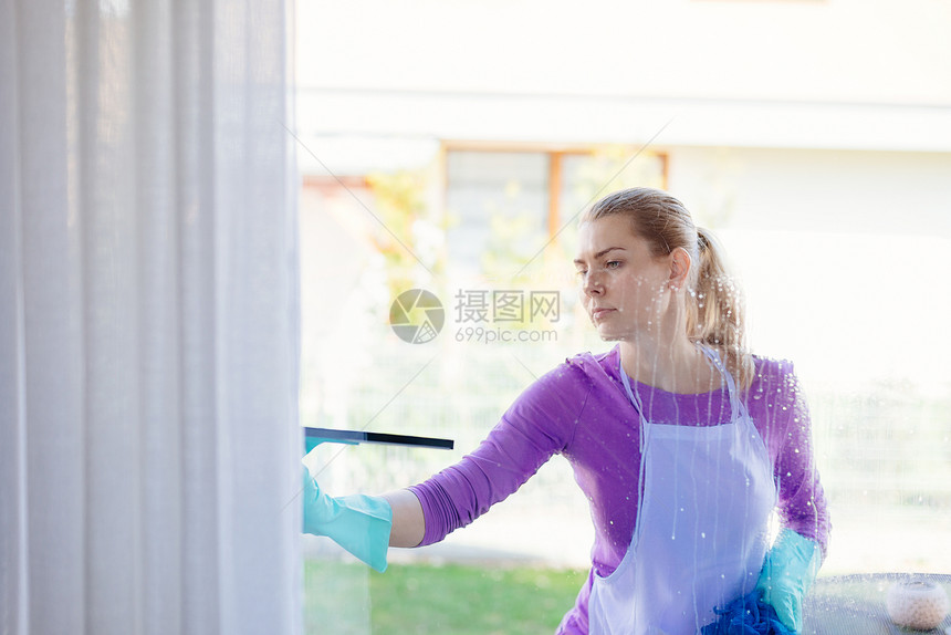 白围裙洗窗的年轻女子清洁服务图片
