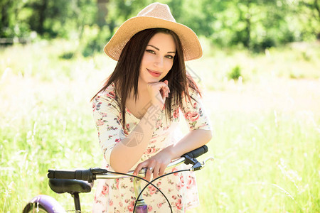 快乐漂亮的年轻女孩在夏天公园骑自行车在城市的快乐放松时间美丽的女人图片