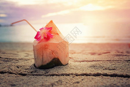 日出时海滩上的新鲜椰子水图片