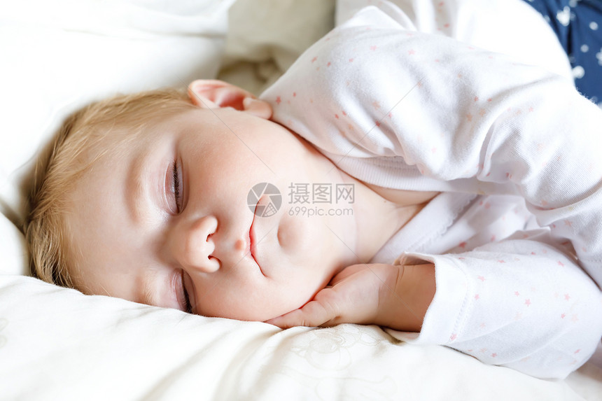 6个月大的可爱女婴在家里安静地睡在床上美丽和平的孩子图片