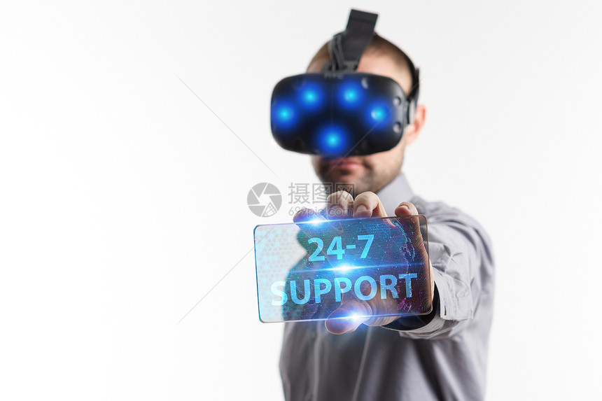 在虚拟现实眼镜中工作的年轻商人看到题词图片