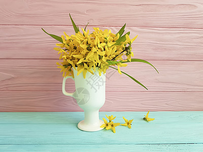 彩色木质背景花瓶中的黄色春花图片