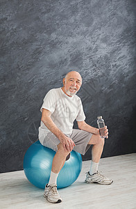 穿着运动服的口渴老人在训练后放松图片