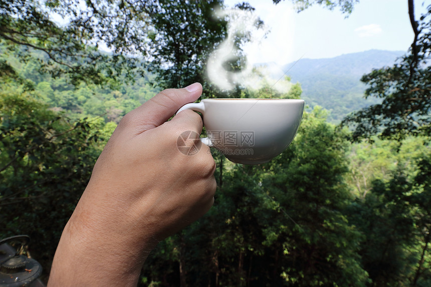 一群年轻游客紧握双手拿着咖啡杯在美丽的清晨自然背景图片