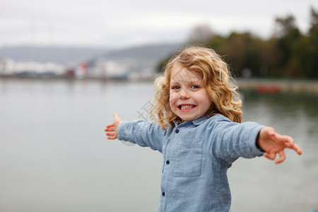 快乐的小男孩一头长的金发在河边张图片