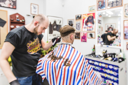 理发店男士理发的模糊形象理发师为客户理发使用剪刀和剪刀图片