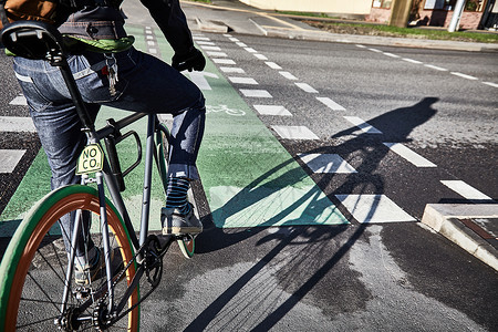 一个骑自行车的人正在骑自行车道城市里的自行车环保的交通方式图片