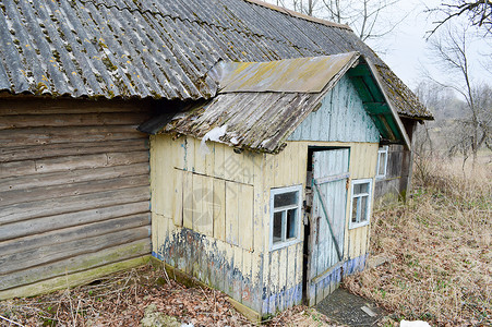 古老破旧的门廊木制村庄房屋入口和荒野中一座废弃村庄房屋被毁坏的原图片