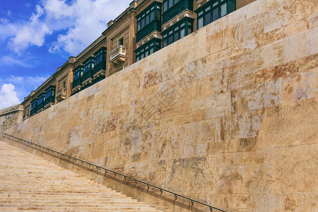 马耳他瓦莱塔历史中心的石楼梯和带金属栏杆的石墙蓝天和传统的马图片