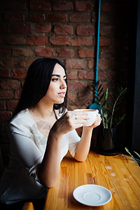 年轻女子在户外咖啡馆喝咖啡图片