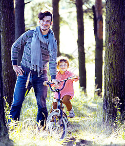 父亲在外边学儿子骑自行车图片